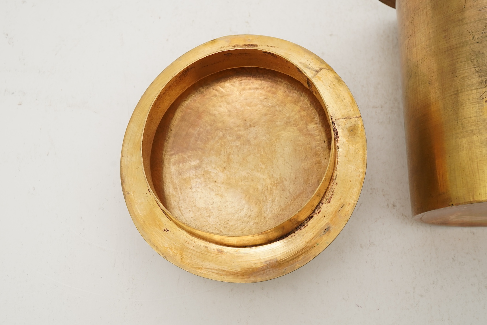 A Chinese pale celadon jade oval plaque, 17th/18th century, mounted on a late Qing gilt copper jar